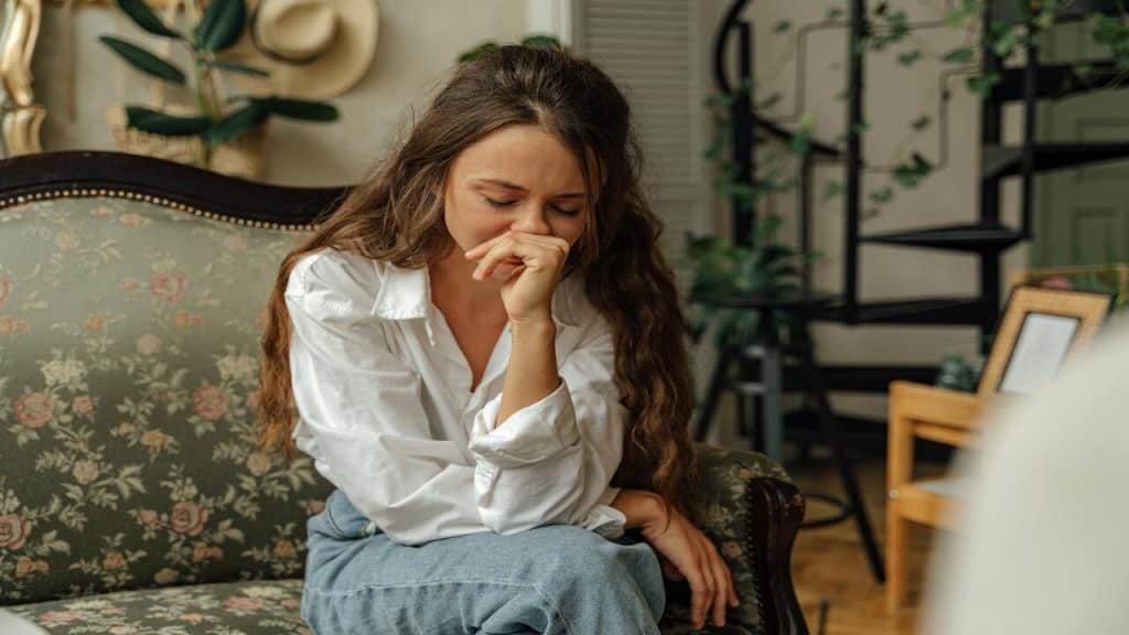 A woman crying on the couch