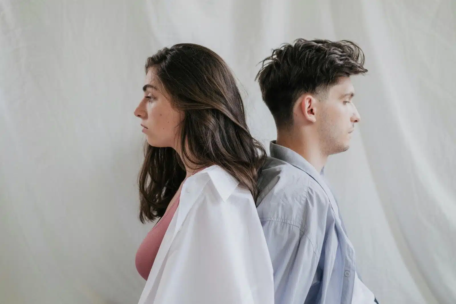 A man and woman sitting back to back