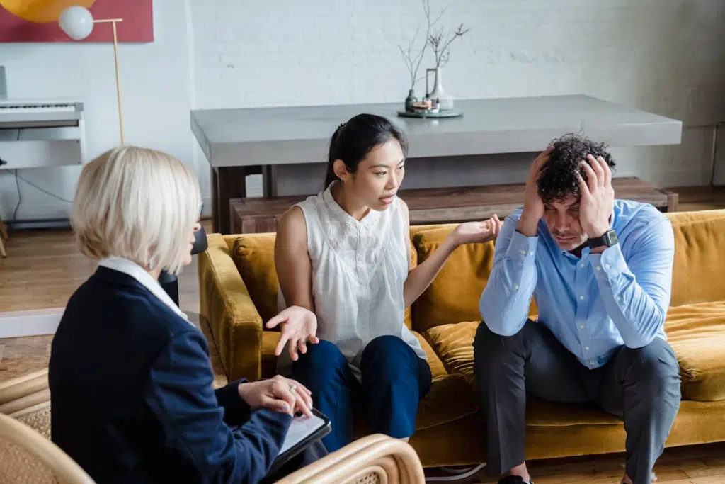 Couple on a Couch Arguing in front of friend