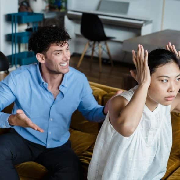 Man shouting and woman covering her ears