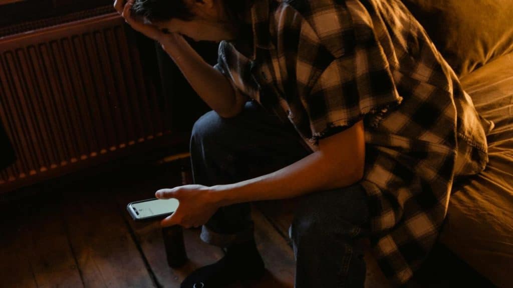 A person sitting and looking at a phone