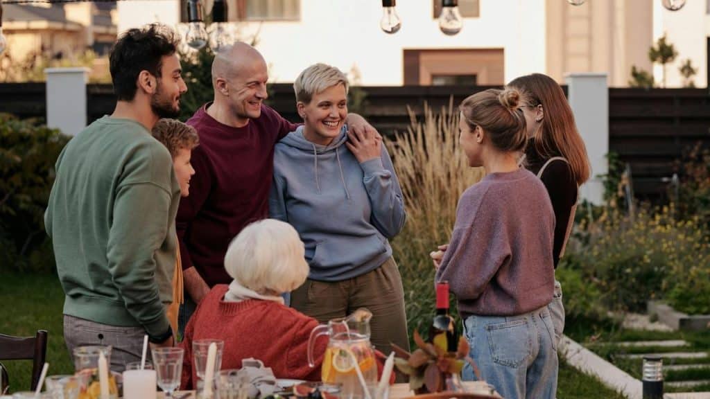 A group of people chatting together at an outdoor gathering.