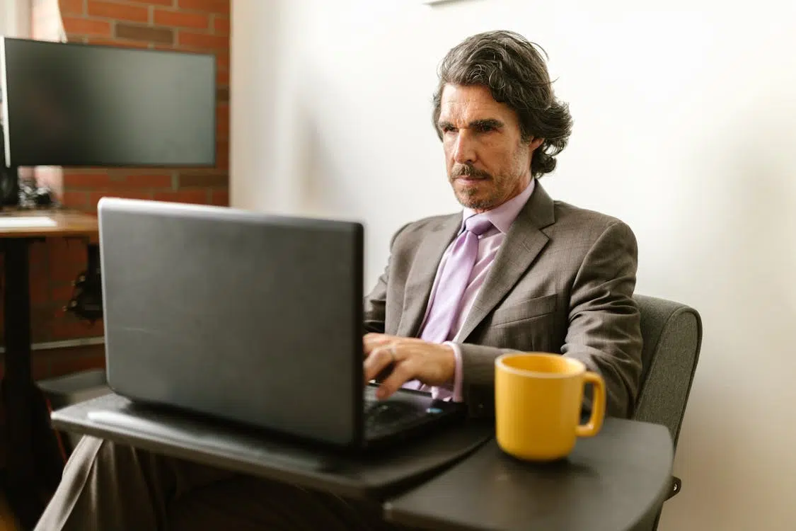 An angry man using a laptop