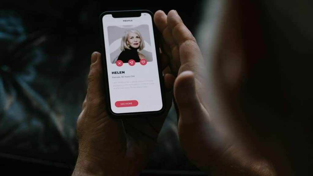 A person viewing a woman’s profile on a dating app.
