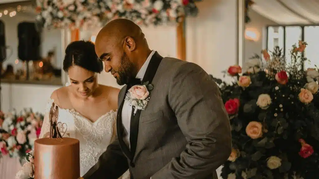 A bride and groom cutting a wedding cake together.