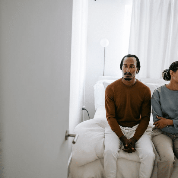 Couple in bed on sitting ignoring each other