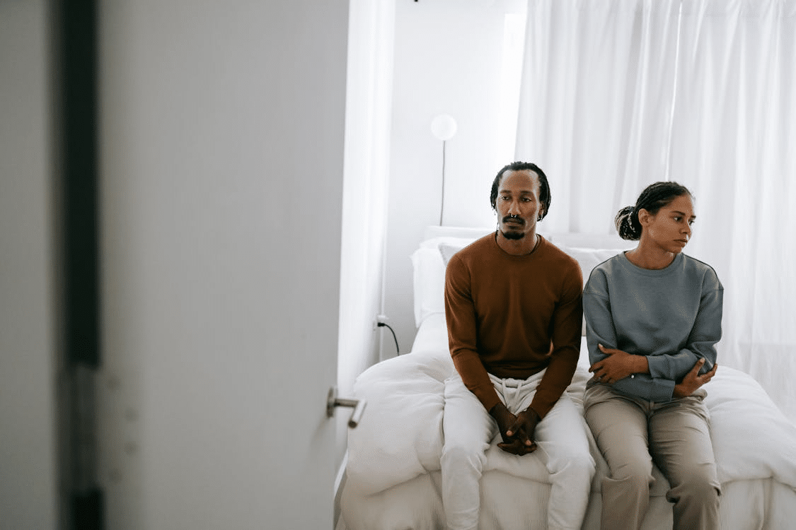 Couple in bed on sitting ignoring each other