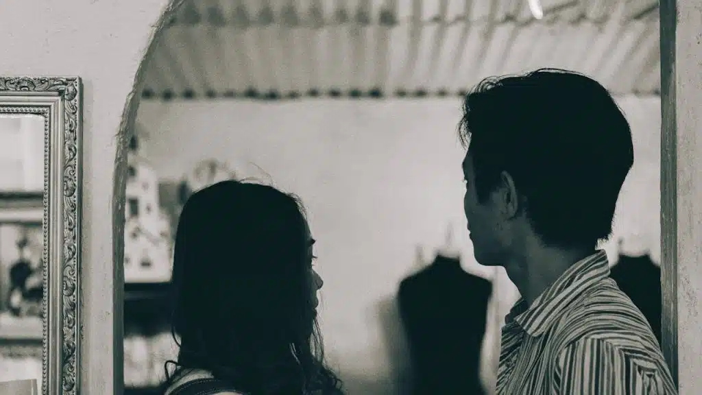 A man and a woman standing in grayscale photography.