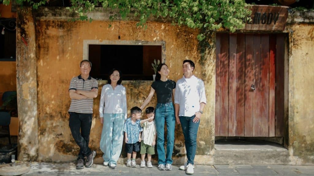 A family standing outside their home and posing for a picture.