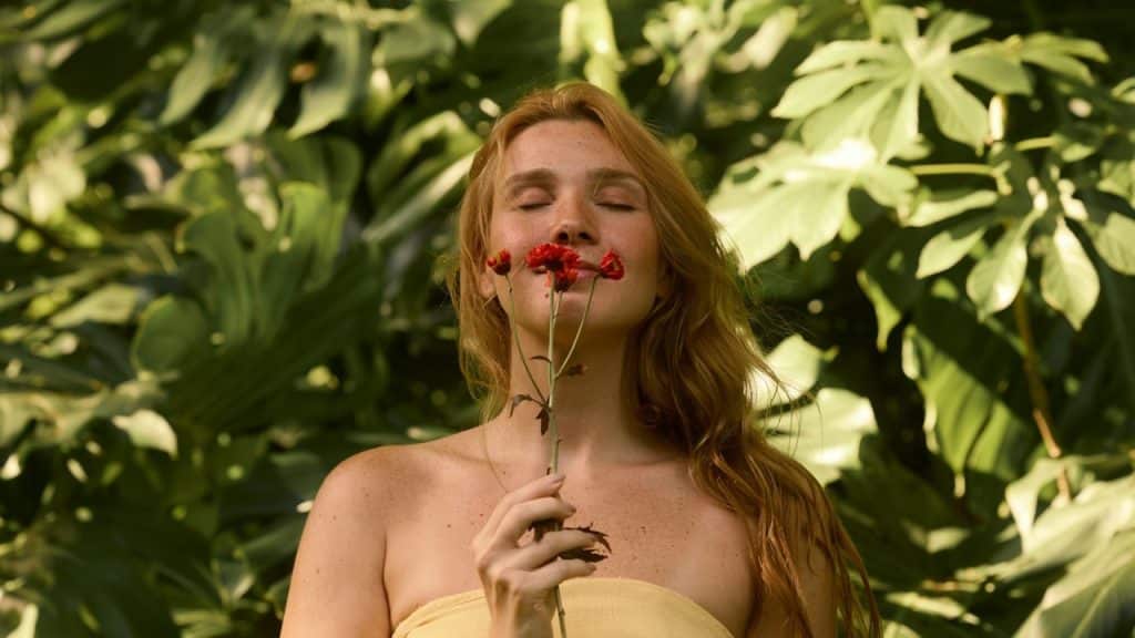 A woman in a yellow dress holding a bunch of flowers.