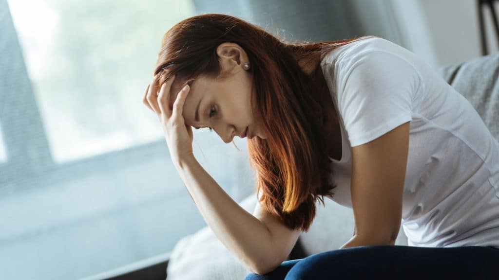 A sad woman holding her head