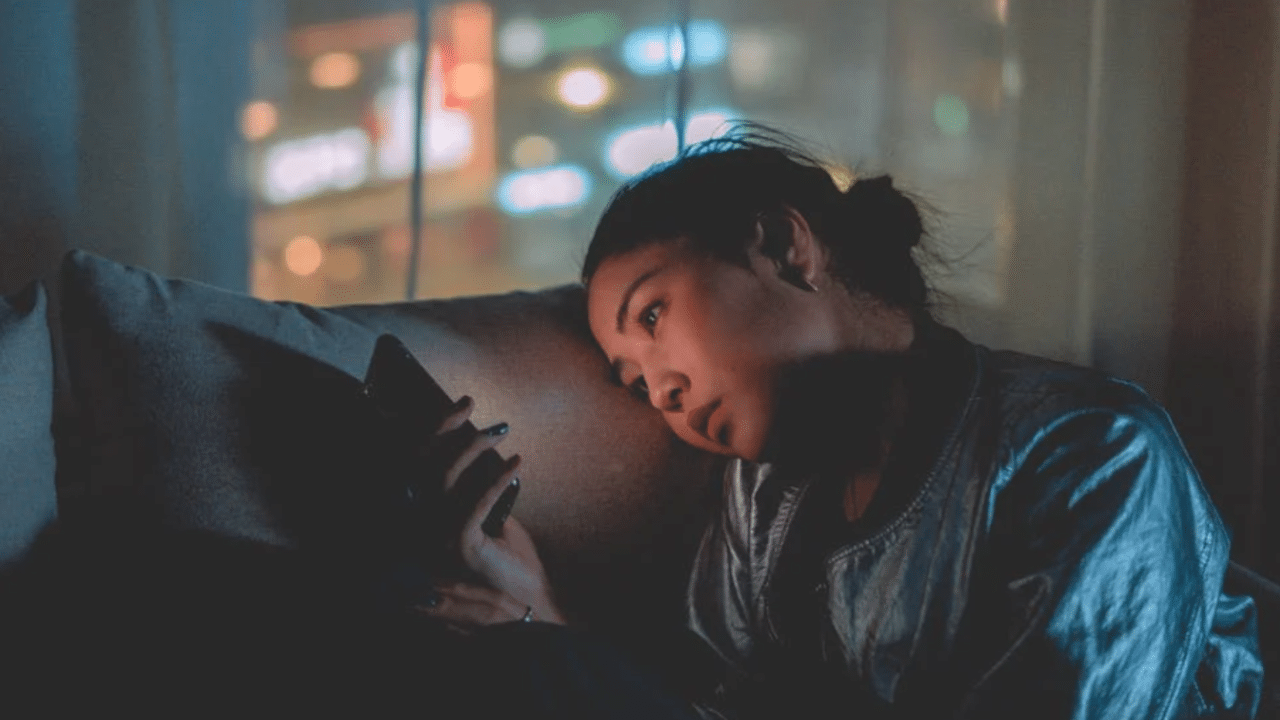 A woman looking sadly at her phone