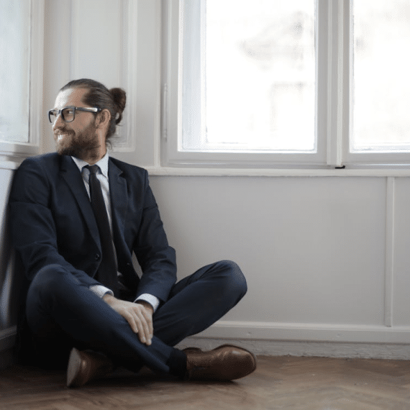 A man smiling while sitting on the floor