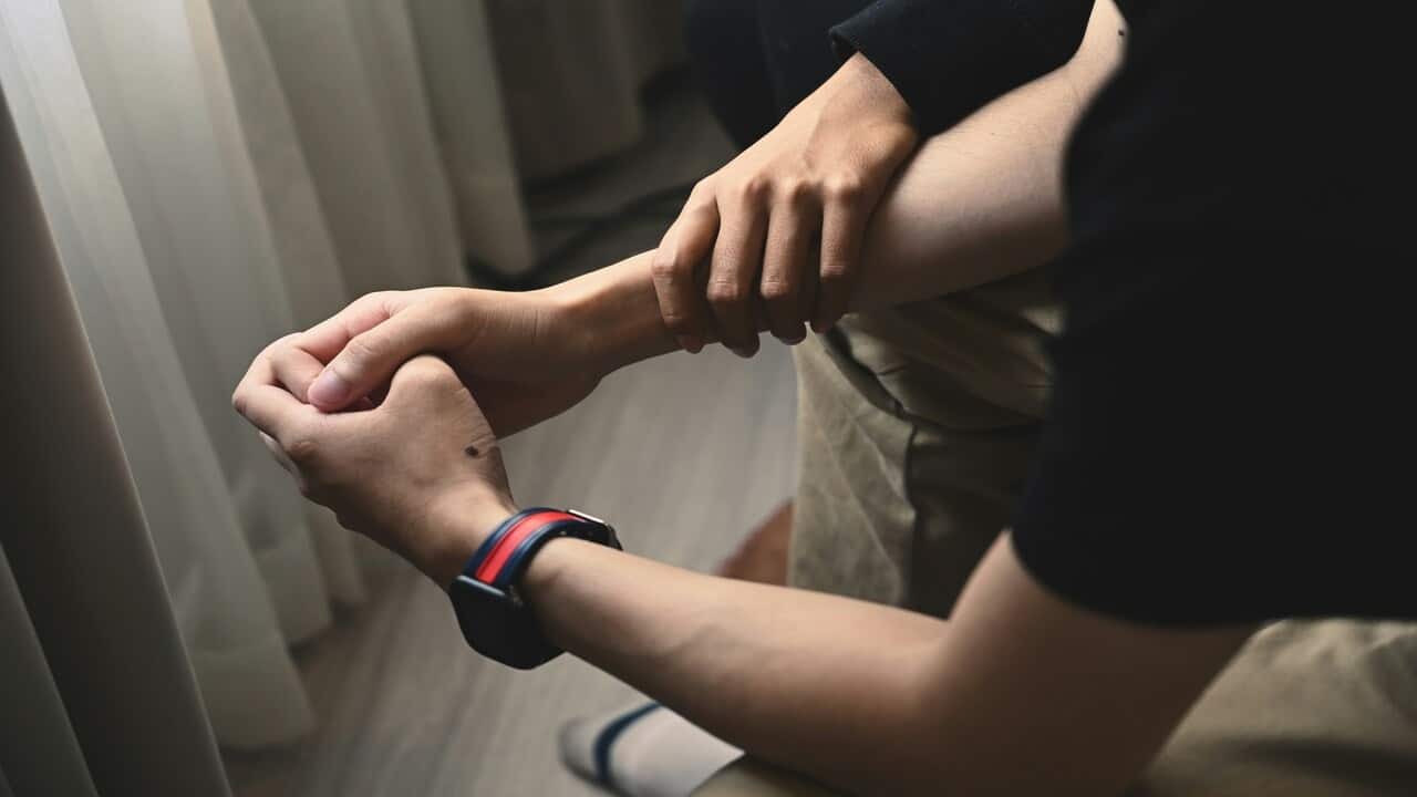 A hand grabbing a man’s wrist