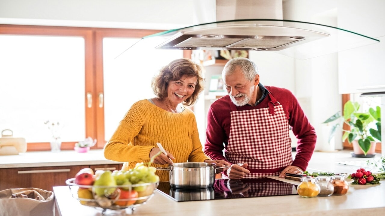 An older couple cooking together