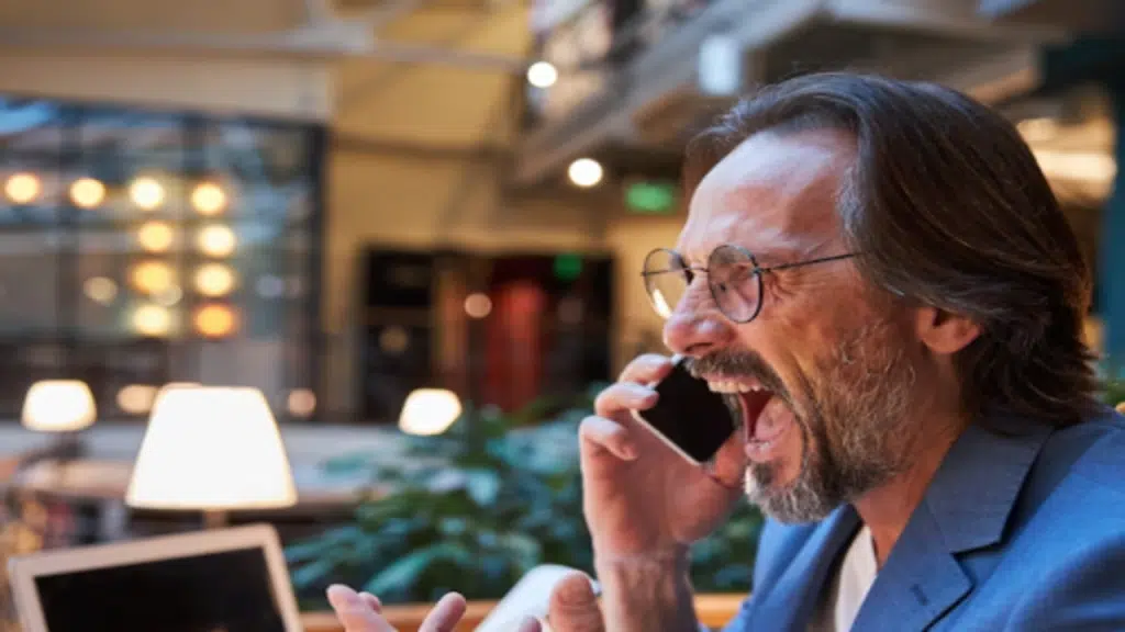 An angry man yelling at the phone
