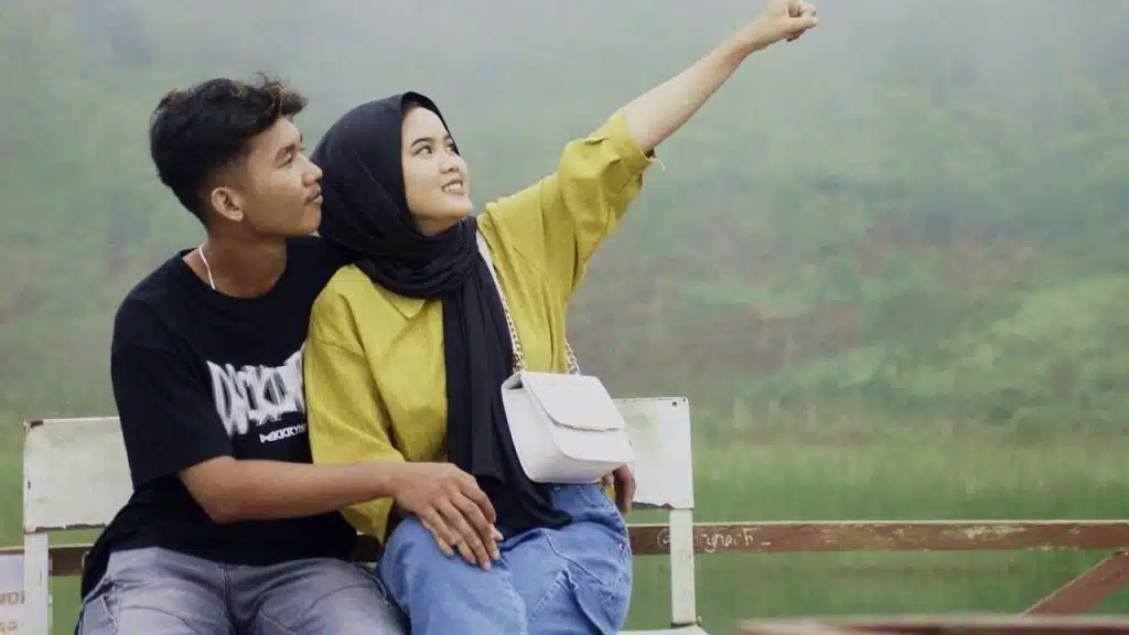 A couple sitting on a bench in nature.