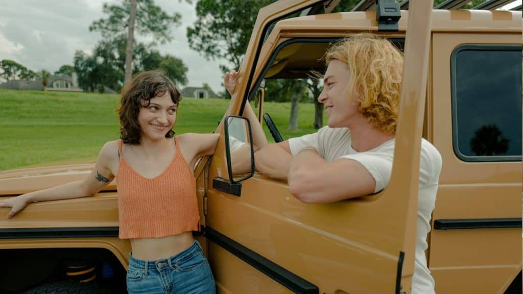 A woman standing next to a man in the back of a truck.