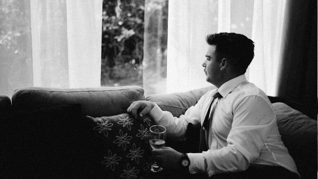 A man sitting on a sofa is looking out of the window.