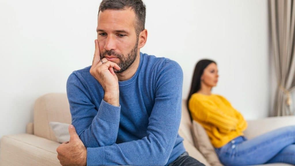 A couple sitting quietly after having an argument at their home.