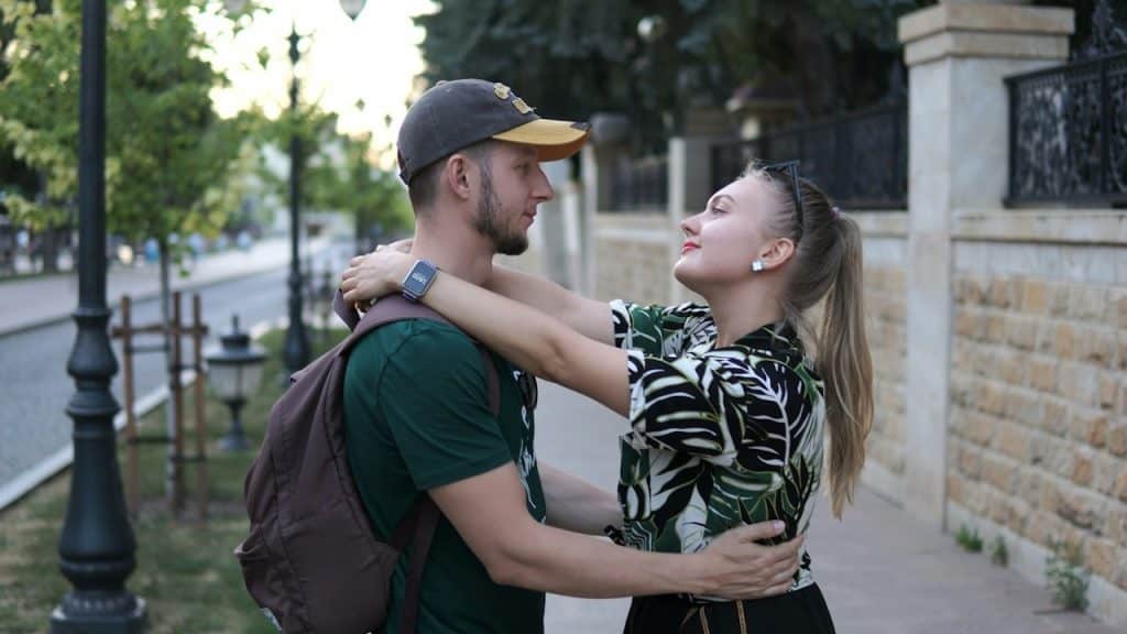 A man standing next to a woman on a sidewalk.