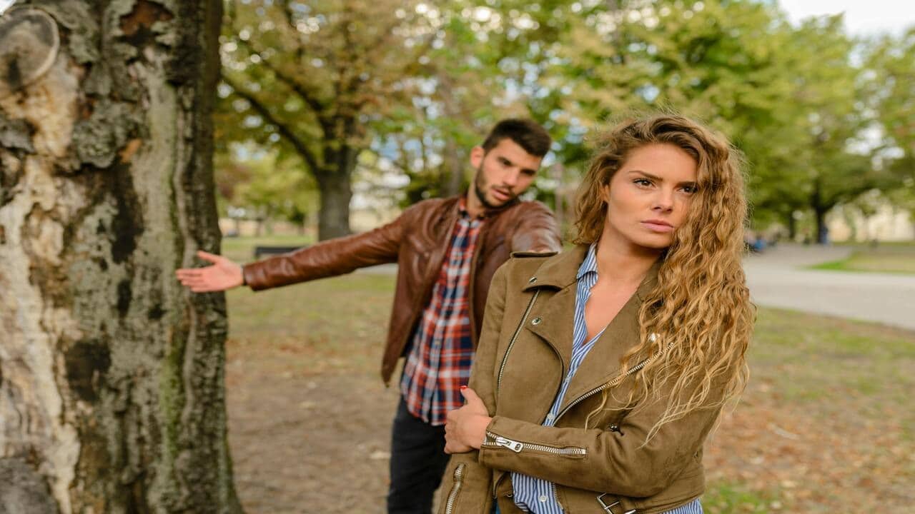 A couple fighting by a tree