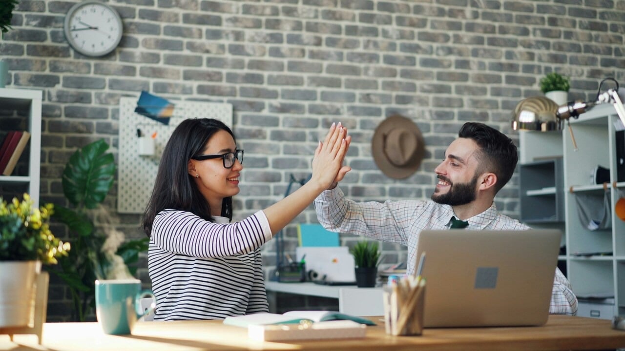 A couple high-fiving at work
