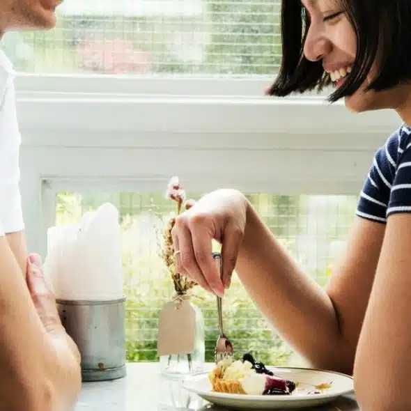 A couple smiling while sharing dessert