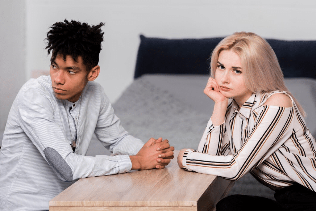 Young couple sitting face to face looking away