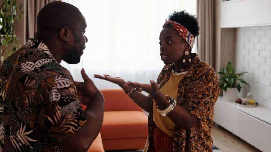 A woman gesturing while arguing with a man