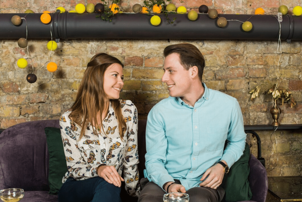 Beautiful couple sitting on couch and looking each other