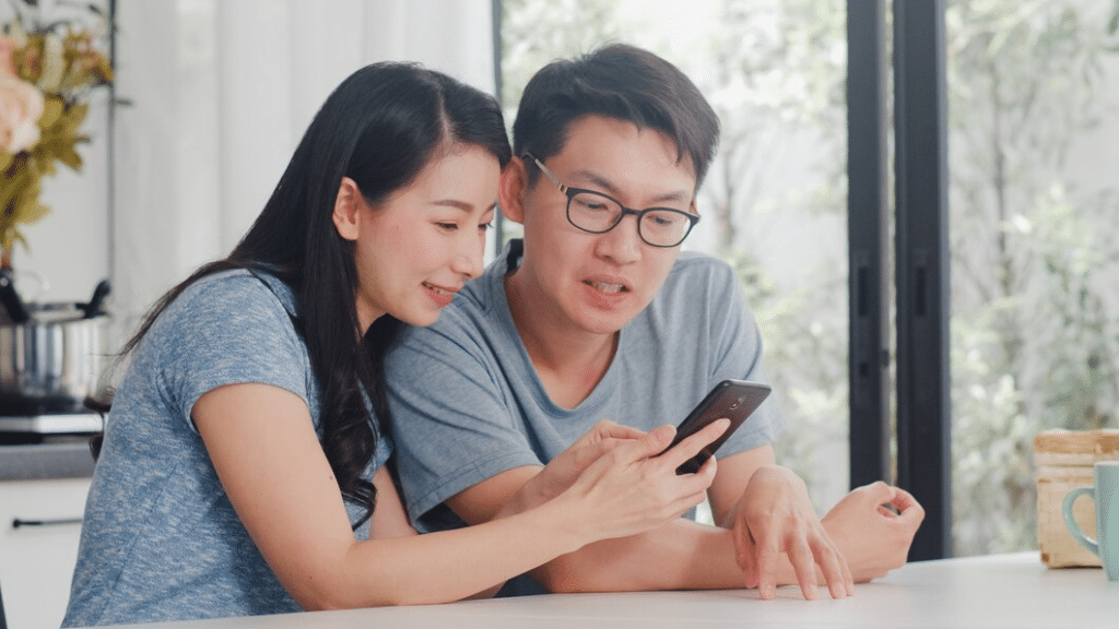 Young couple sitting at counter looking at expenses