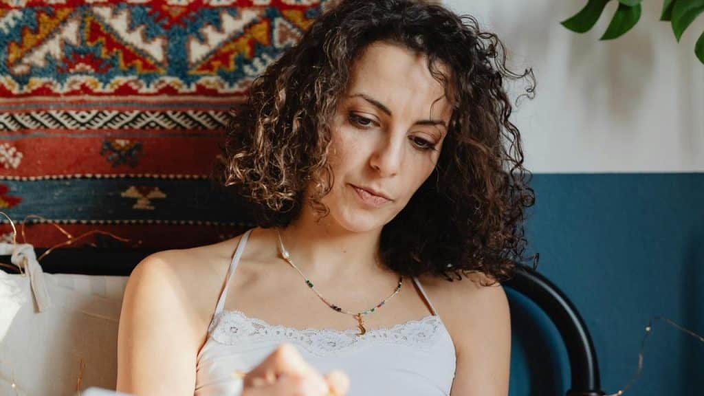A woman with curly hair looking down