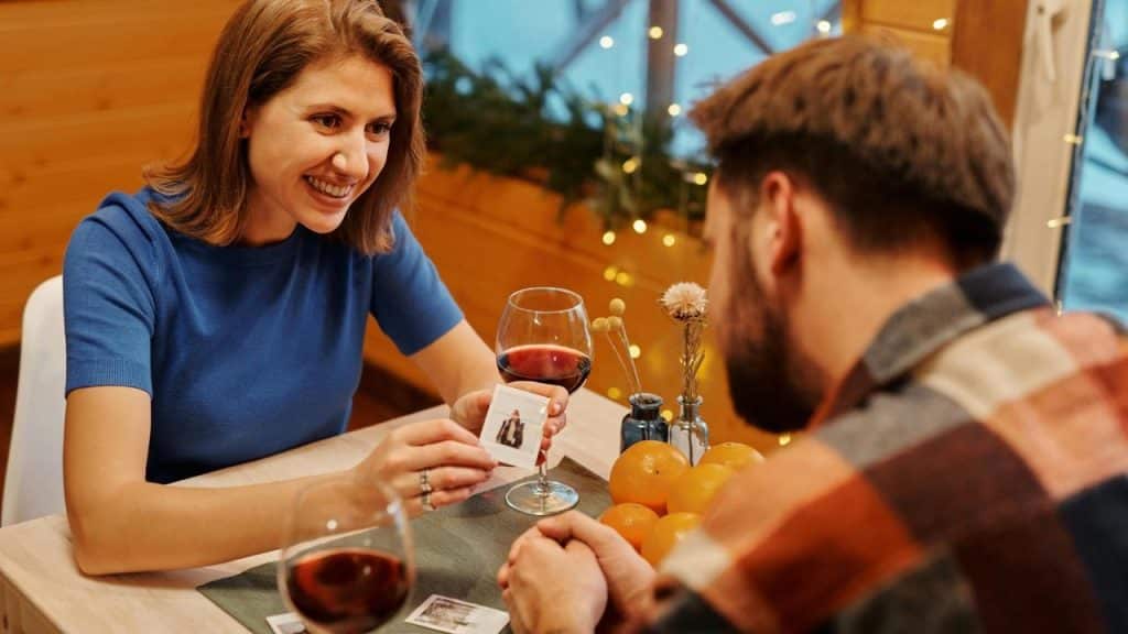 A woman smiling and showing a small photo to a man
