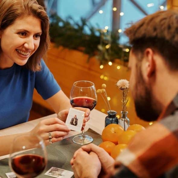 A woman smiling and showing a small photo to a man