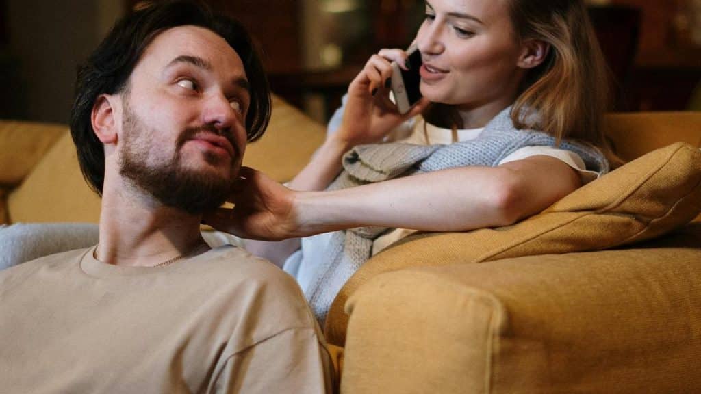 A woman talking on the phone while sitting beside a man