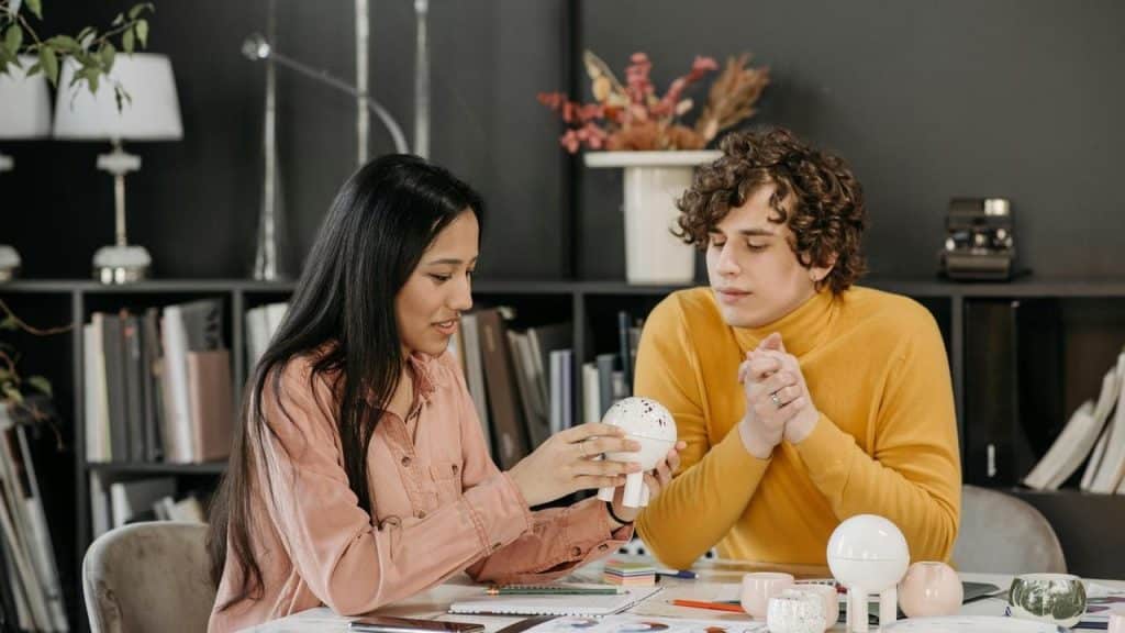 A woman showing a small model to a man
