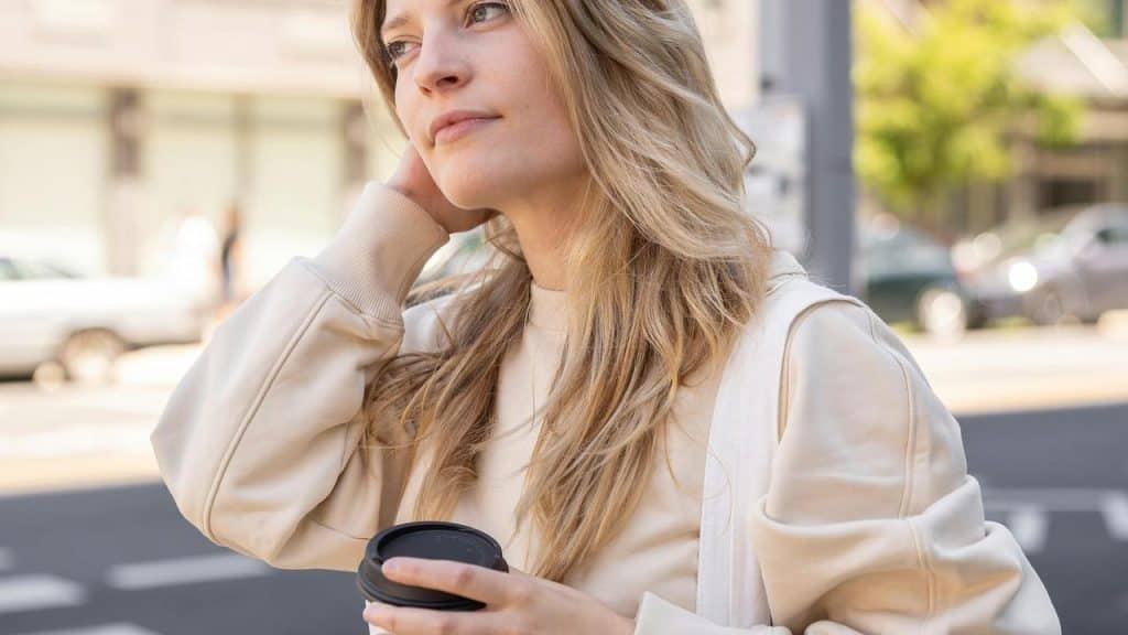 A woman holding a takeaway coffee cup