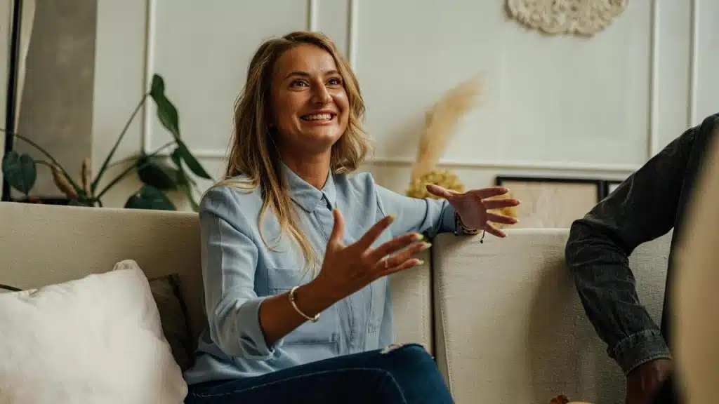 A smiling woman gesturing with her hands 