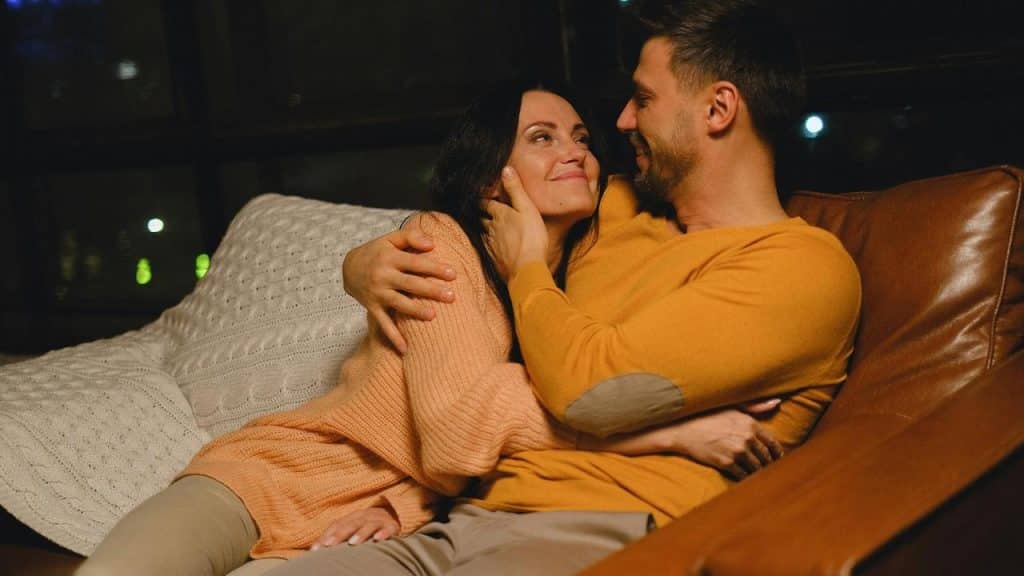 A couple cuddling on a couch