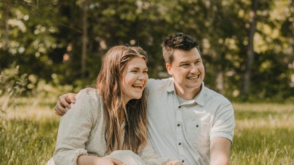 A happy couple sitting on the grass