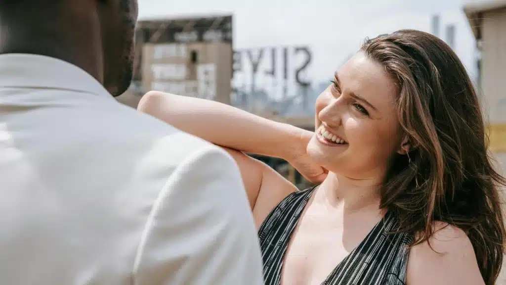 A smiling woman talking with a man