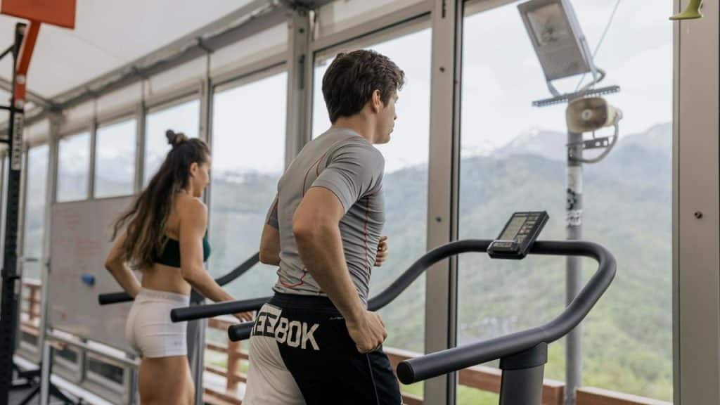 A man and a woman running on treadmills 