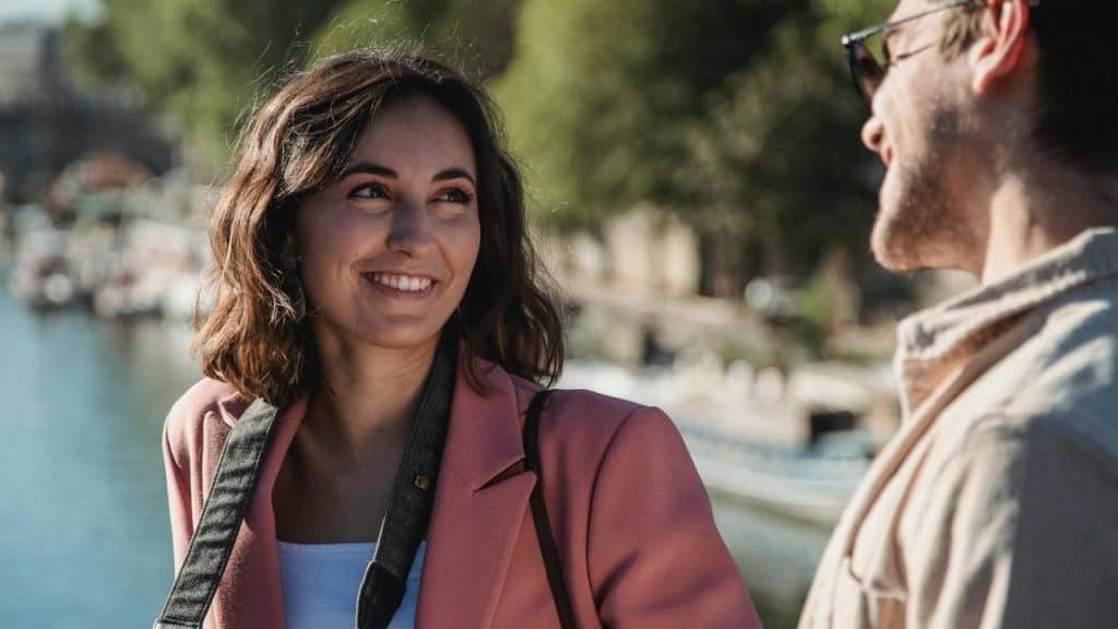 A smiling woman talking with a man