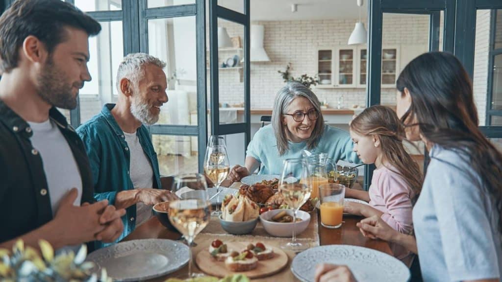 A family gathered around a dining table enjoying a meal together.