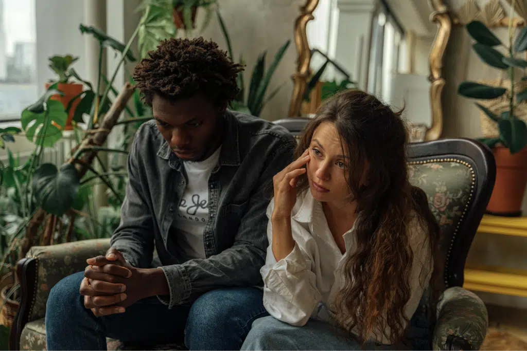 Unhappy Couple Sitting Next to Each Other on a Couch