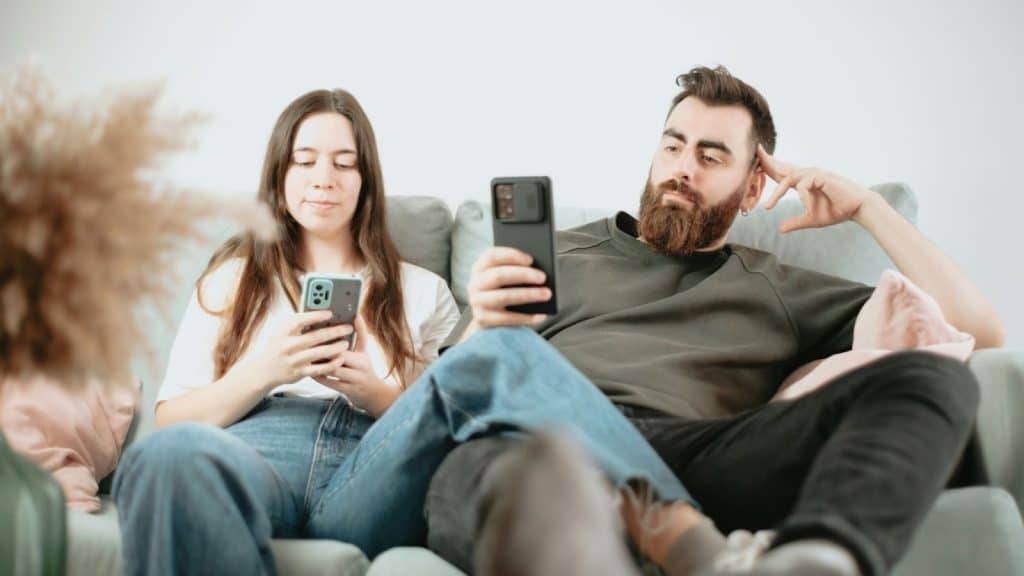 A man and woman busy with their phone