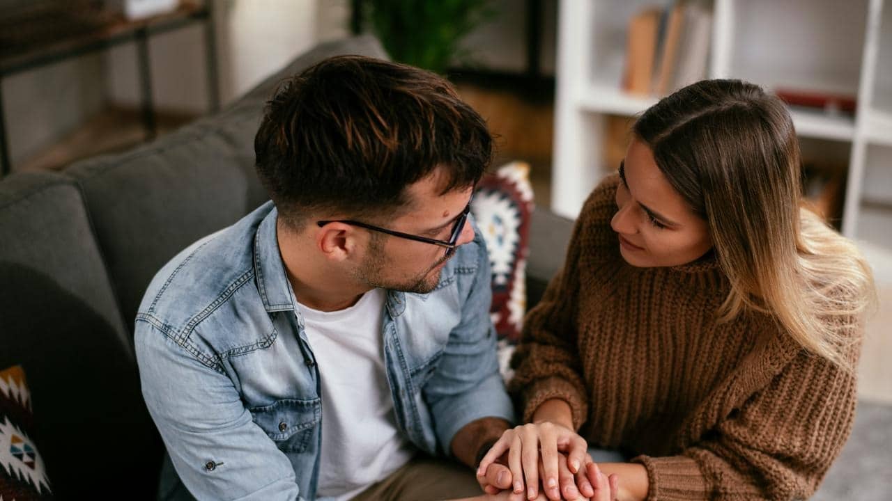 A couple sitting close together on a couch