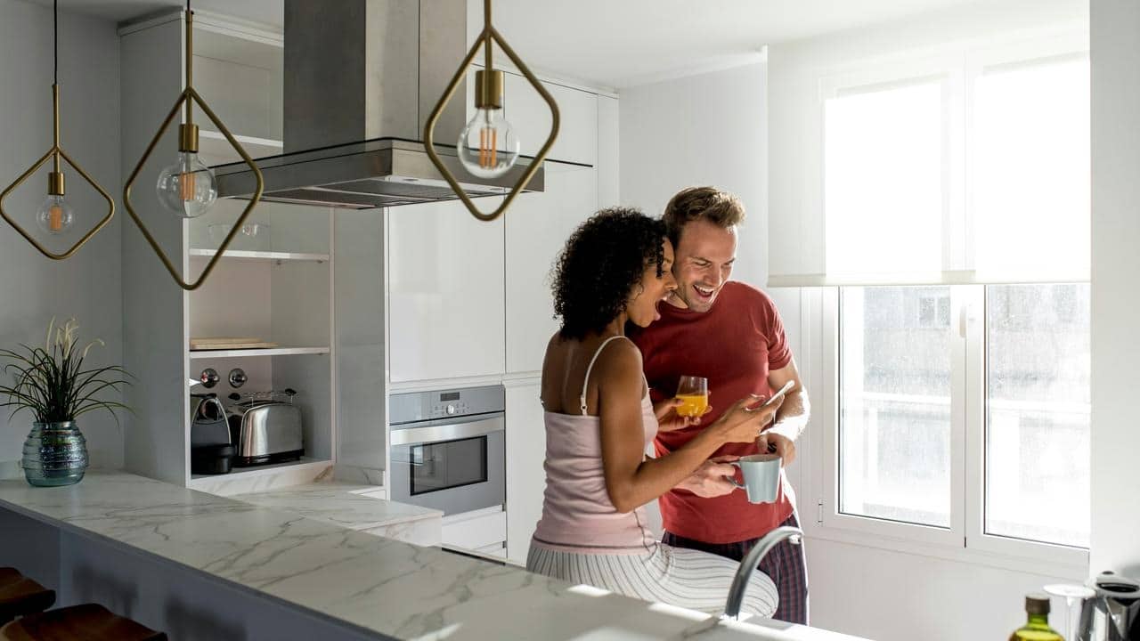 A couple standing together in a bright kitchen