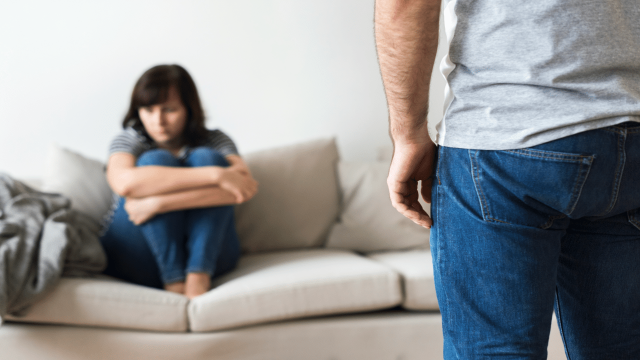 A woman looking upset while her husband berates her